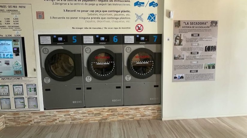 El kiosco de pago con pantalla táctil junto a las tres secadoras Girbau de 17 kg